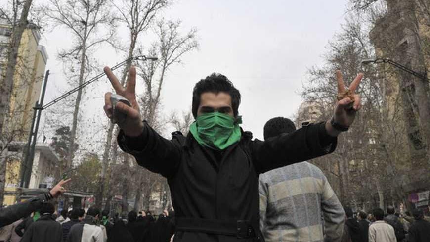 EDITORS' NOTE: Reuters and other foreign media are subject to Iranian restrictions on their ability to film or take pictures in Tehran.

An Iranian protestor with his face covered with a green mask flashes the victory sign as he holds stones in his hands during clashes in central Tehran December 27, 2009. A senior Iranian police official denied a report on an opposition website that four pro-reform protesters were killed during clashes in Tehran on Sunday, the Students News Agency ISNA reported. REUTERS/S