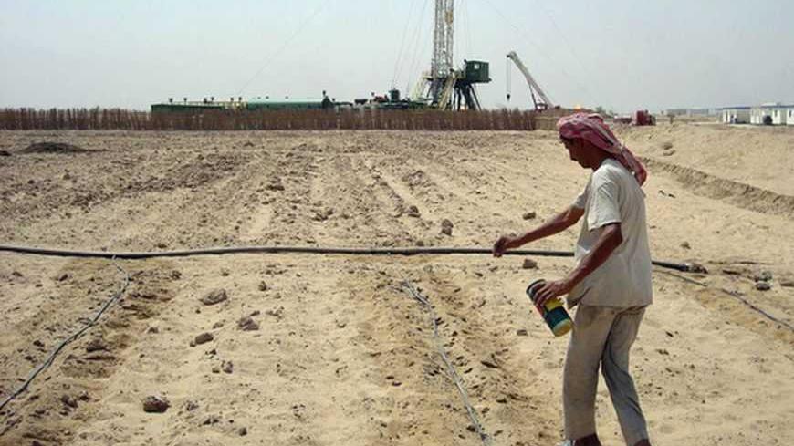 A farmer sows seeds of cucumber at his farm near an oilfield in Iraq's southern province of Basra August 12, 2010. The fertile acreage atop some of the world's largest oilfields has been farmed for dates, melons and vegetables for centuries but the tribes that work the land fear they are being pushed aside in the rush to develop Iraq's vast reserves. Picture taken August 12, 2010. To match Feature IRAQ-OIL/FARMS  REUTERS/Stringer (IRAQ - Tags: ENERGY AGRICULTURE BUSINESS) - RTR2HDNU