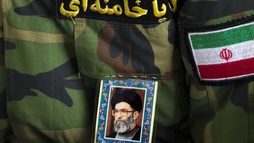EDITORS' NOTE: Reuters and other foreign media are subject to Iranian restrictions on leaving the office to report, film or take pictures in Tehran.

A worshipper pastes a portrait of Iran's Supreme Leader Ayatollah Ali Khamenei, a flag and a Persian script that reads, "Hey Khamenei" on a Revolutionary Guard uniform as he attends Friday prayers in Tehran February 10, 2012. REUTERS/Morteza Nikoubazl (IRAN - Tags: POLITICS RELIGION MILITARY)