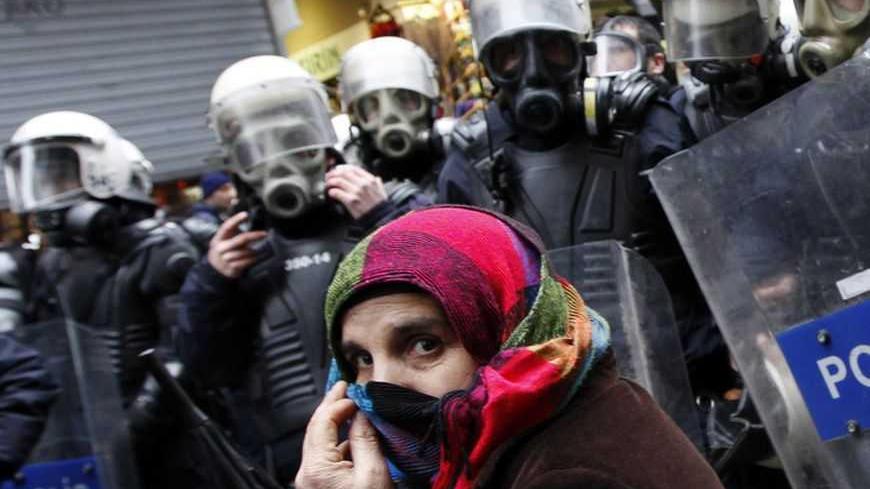 A pro-Kurdish demonstrator covers her face as riot police prevent protestors from marching, at Taksim square in central Istanbul February 15, 2012. Supporters of the pro-Kurdish Peace and Democracy Party (BDP) held a protest to mark the 13th anniversary of the capture of Kurdistan Workers' Party (PKK) leader Abdullah Ocalan. REUTERS/Murad Sezer (TURKEY - Tags: POLITICS CIVIL UNREST CRIME LAW) - RTR2XWBQ
