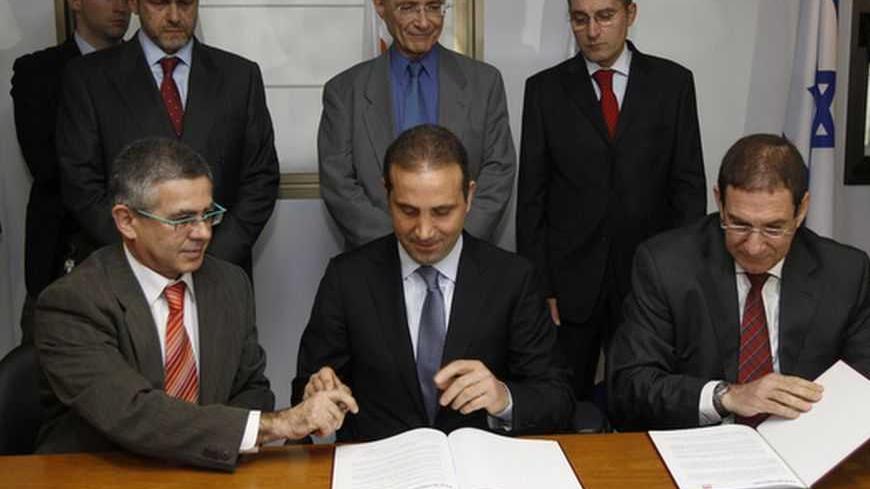 Israel's Energy Minister Uzi Landau (rear C) watches as Nasos Ktorides (front C), chairman of DEH Quantum Energy, and Israel Electric Corp (IEC) Chairman Yiftach Ron-Tal (front R) sign a memorandum of understanding in Jerusalem March 4, 2012. Israel and Cyprus began a feasibility study on Sunday for the construction of an underwater electric cable between the two countries that would ensure their energy security and offer Israel a channel to export energy to Europe. REUTERS/Ronen Zvulun (JERUSALEM - Tags: P