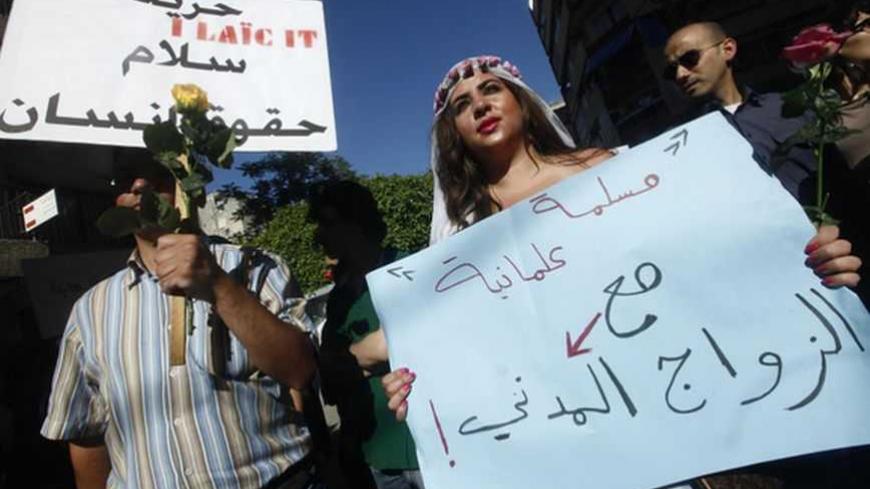 A Lebanese activist, dressed as a bride, carries a sign during the Lebanese Laique Pride, a secular march towards citizenship, in Beirut May 6, 2012. The signs read, "A Muslim secular supporting the civil marriage" and "Freedom, peace, human rights" (L). REUTERS/Wadih Shlink   (LEBANON - Tags: POLITICS CIVIL UNREST SOCIETY IMMIGRATION) - RTR31OXC