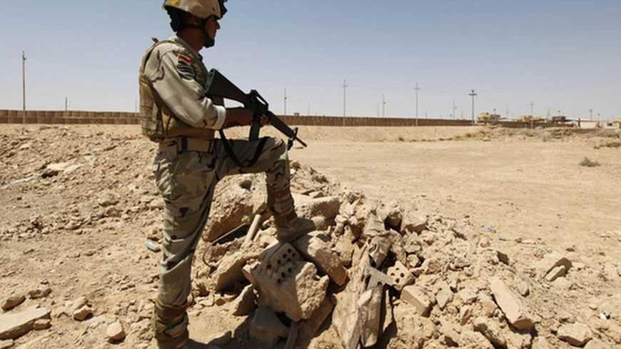 An Iraqi soldier stands guard near Iraqi-Syrian borders at the Abu Kamal-qaim border crossing, the main border post between Iraq and Syria, July 20, 2012. REUTERS/Saad Shalash (IRAQ - Tags - Tags: CIVIL UNREST MILITARY)