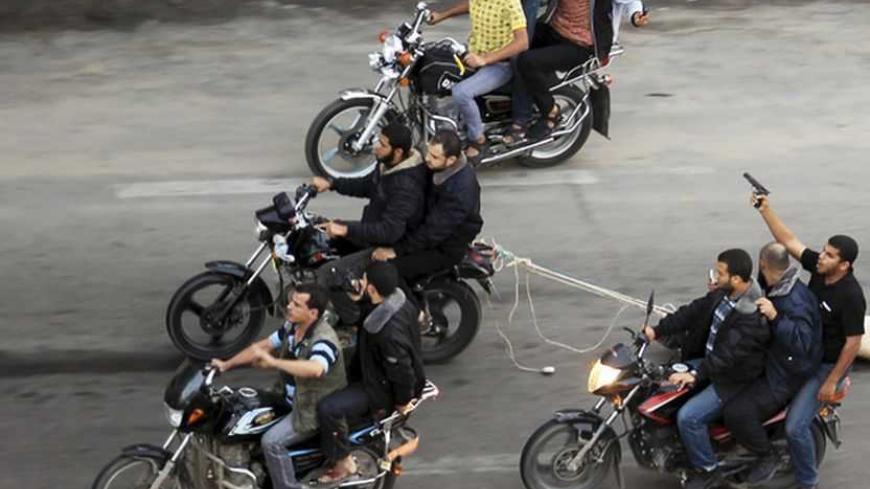 Palestinian gunmen ride motorcycles as they drag the body of a man (not seen), who was suspected of working for Israel, in Gaza City November 20, 2012. Palestinian gunmen shot dead six alleged collaborators in the Gaza Strip who "were caught red-handed", according to a security source quoted by the Hamas Aqsa radio on Tuesday. REUTERS/Suhaib Salem (GAZA - Tags: POLITICS CIVIL UNREST TPX IMAGES OF THE DAY) - RTR3ANXW