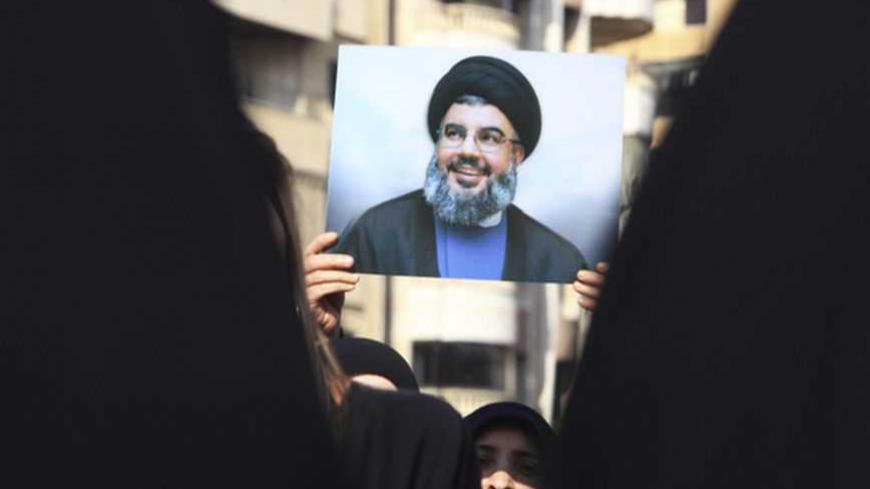 A Lebanese Hezbollah supporter carries a picture of Hezbollah leader Sayyed Hassan Nasrallah as she takes part in a ceremony marking Ashura in Beirut's suburbs, November 25, 2012. Hezbollah leader Sayyed Hassan Nasrallah warned Israel on Sunday that thousands of rockets would rain down on Tel Aviv and other Israeli cities if Israel attacked Lebanon. In a speech marking the Shi'ite Muslim festival of Ashura, Nasrallah said Hezbollah's response to any attack would dwarf the attacks from Gaza during the eight-