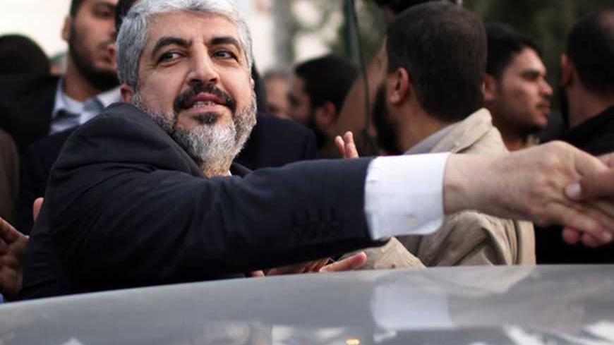 Hamas chief Khaled Meshaal shakes hands with a man as he leaves the Rafah border crossing in the southern Gaza Strip December 10, 2012. Hamas leader Meshaal ended his first visit to the Gaza Strip on Monday with a pledge his Islamist movement would strive to heal political rifts with Palestinian rivals who hold sway in the occupied West Bank. REUTERS/Ahmed Jadallah (GAZA - Tags: POLITICS)