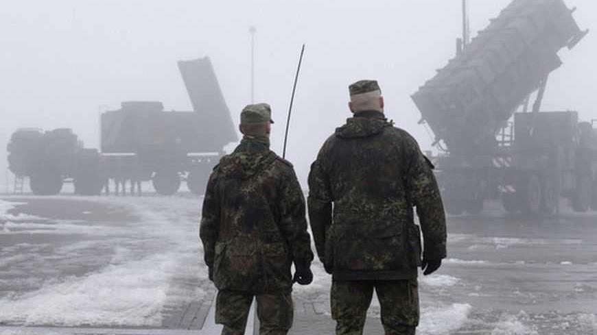 Soldiers of the German armed forces Bundeswehr stand next to a radar-unit (L) and a PAC-2 launcher of a "Patriot" missile battery during a press rehearsal in the north German village of Warbelow December 18, 2012. Germany's lower house of parliament, the Bundestag, last week approved the sending of two Patriot batteries and 400 soldiers to Turkey as part of a NATO plan to protect the country from any spread of the Syrian conflict. REUTERS/Tobias Schwarz (GERMANY - Tags: POLITICS MILITARY CONFLICT)