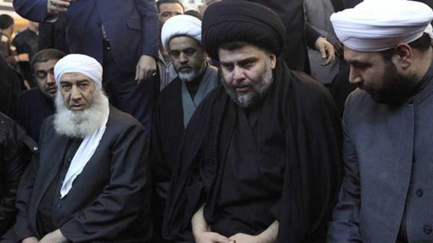 Iraqi Shi'ite cleric Moqtada al-Sadr (C) takes part in Friday prayers participated by Sunni and Shi'ite Muslim worshippers in a gesture of unity at the Abdul Qadir Gilani Mosque in Baghdad January 4, 2013.  REUTERS/Thaier Al-Sudani (IRAQ - Tags: RELIGION)