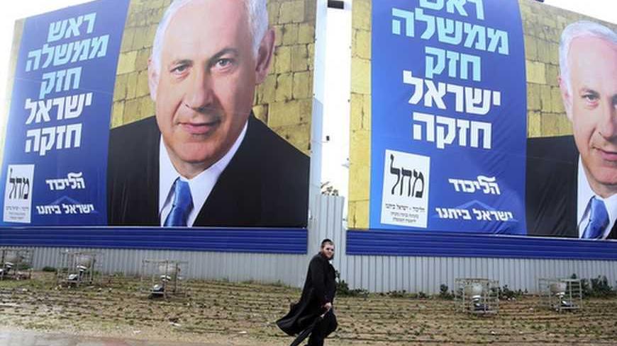 A pedestrian walks past campaign posters depicting Israel's Prime Minister Benjamin Netanyahu in Bnei Brak near Tel Aviv January 7, 2013. Three Israeli centrist and left-leaning parties have failed in an initial attempt to form a united bloc that might have cut into Netanyahu's opinion poll lead before the Jan. 22 election.  REUTERS/Baz Ratner (ISRAEL - Tags: POLITICS ELECTIONS)