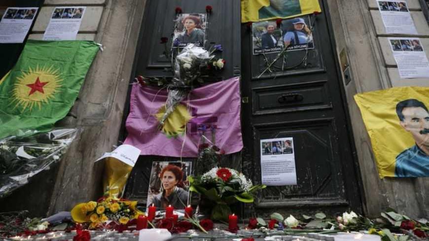 Flags, flowers and candles displayed by members of the Kurdish community are seen in front of the entrance of the Information Centre of Kurdistan in Paris, where three Kurdish women were found shot dead, January 11, 2013. Three female Kurdish activists including a founding member of the PKK rebel group were shot dead in Paris, January 10, 2013, in execution-style killings condemned by Turkish politicians trying to broker a peace deal. REUTERS/Christian Hartmann (FRANCE - Tags: POLITICS CRIME LAW)