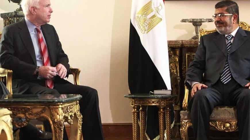 Egyptian President Mohamed Mursi (R) talks with U.S. Senator John McCain during their meeting in Cairo January 16, 2013. REUTERS/Asmaa Waguih (EGYPT - Tags: POLITICS)