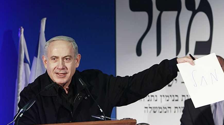 Israel's Prime Minister Benjamin Netanyahu holds up a paper inscribed with his party's initials during a Likud-Yisrael Beitenu campaign rally in the southern city of Ashdod January 16, 2013. Netanyahu's right-wing Likud party, allied with the nationalist Yisrael Beitenu party, continues to lead opinion polls ahead of Israel's Jan. 22 parliamentary election. REUTERS/Amir Cohen (ISRAEL - Tags: POLITICS ELECTIONS)