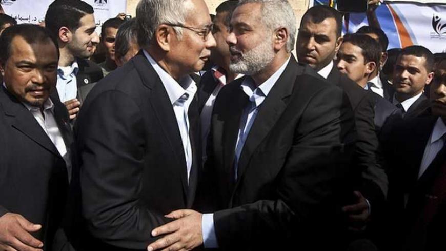 Malaysian Prime Minister Najib Razak (L) hugs senior Hamas leader Ismail Haniyeh during a cornerstone placing ceremony in Gaza City January 22, 2013. REUTERS/Ali Ali/Pool (GAZA - Tags: POLITICS)