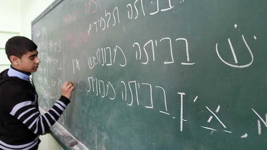 A Palestinian ninth grade student writes on the blackboard during a Hebrew class at a Gaza school in Gaza City January 28, 2013. REUTERS/Ahmed Zakot (GAZA - Tags: EDUCATION) - RTR3D31S