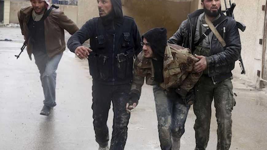 Free Syrian Army fighters help an injured comrade (2nd R) during heavy fighting in the Ain Tarma neighbourhood of Damascus January 30, 2013. REUTERS/Mohammed Abdullah (SYRIA - Tags: CONFLICT CIVIL UNREST POLITICS TPX IMAGES OF THE DAY) - RTR3D5SX