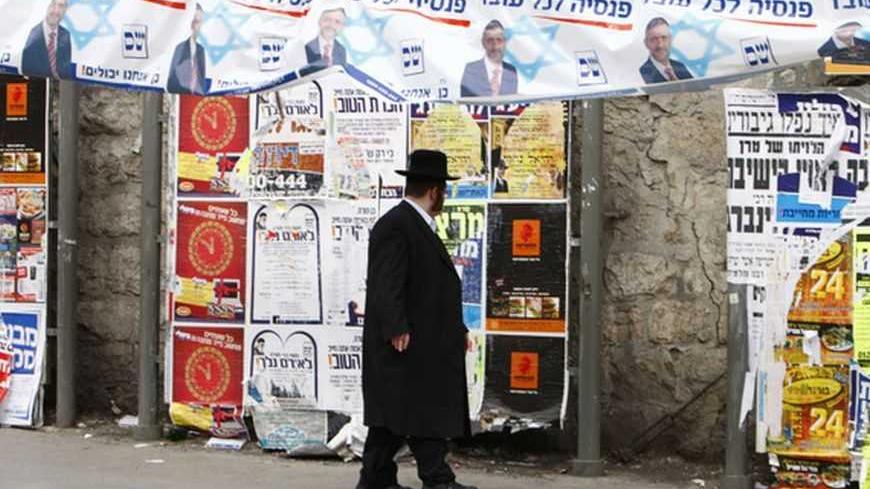 An ultra-Orthodox Jew walks under a "Shas" campaign banner depicting Eli Yishai, the leader of the Orthodox Jewish party, in Jerusalem's Mea Shearim neighbourhood Febraury 8, 2009. Benjamin Netanyahu will go into Tuesday's Israeli election with centrist Foreign Minister Tzipi Livni breathing down his neck and a far-right party siphoning votes from him, according to final opinion polls on Friday. The banner reads in Hebrew "pension for every worker."
REUTERS/Yannis Behrakis (JERUSALEM)