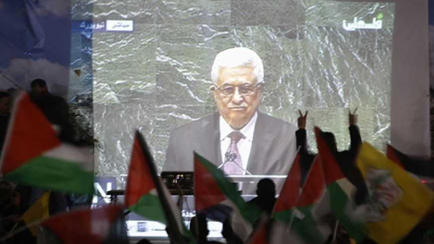 Palestinians take part in a rally while the speech of Palestinian President Mahmoud Abbas is being projected in the West Bank city of Ramallah November 29, 2012. The 193-nation U.N. General Assembly overwhelmingly approved a resolution on Thursday to upgrade the Palestinian Authority's observer status at the United Nations from "entity" to "non-member state," implicitly recognizing a Palestinian state.   REUTERS/Mohamad Torokman (WEST BANK - Tags: POLITICS)