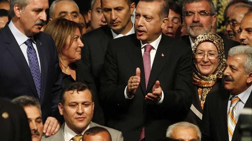 Turkey's Prime Minister and leader of Justice and Development Party (AKP) Tayyip Erdogan (C), accompanied by Numan Kurtulmus, head of the former Islamist-rooted HAS Party (L),  pose with the new members of his party during a party meeting in Istanbul September 22, 2012. The party's September 30, 2012 congress is unlikely to offer any sign Prime Minister Erdogan, viewed by many Turks as their strongest leader since Ataturk, is loosening his grip on a heavily-centralised party or on the country as a whole.  P