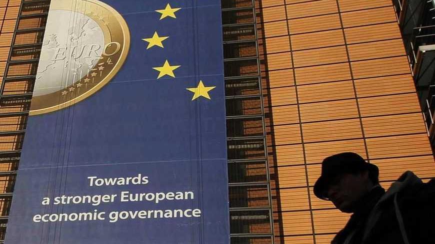 A banner featuring a Euro coin is seen on the European Commission headquarters building in Brussels December 19, 2011.     REUTERS/Yves Herman (BELGIUM - Tags: POLITICS BUSINESS) - RTR2VFYJ