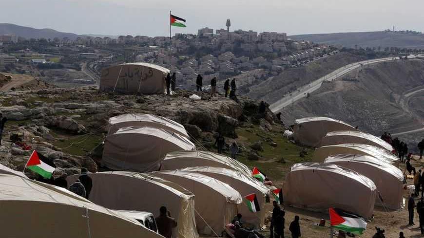 Palestinians, together with Israeli and foreign activists, stand near newly-erected tents in an area known as E1, near Jerusalem January 12, 2013. Palestinians from villages in the occupied West Bank near Jerusalem pitched tents on Friday on the land Israel has earmarked for a new urban settlement, looking to preserve the area for an independent Palestinian state.  REUTER/Baz Ratner (WEST BANK - Tags: POLITICS CIVIL UNREST BUSINESS CONSTRUCTION) - RTR3CD0D