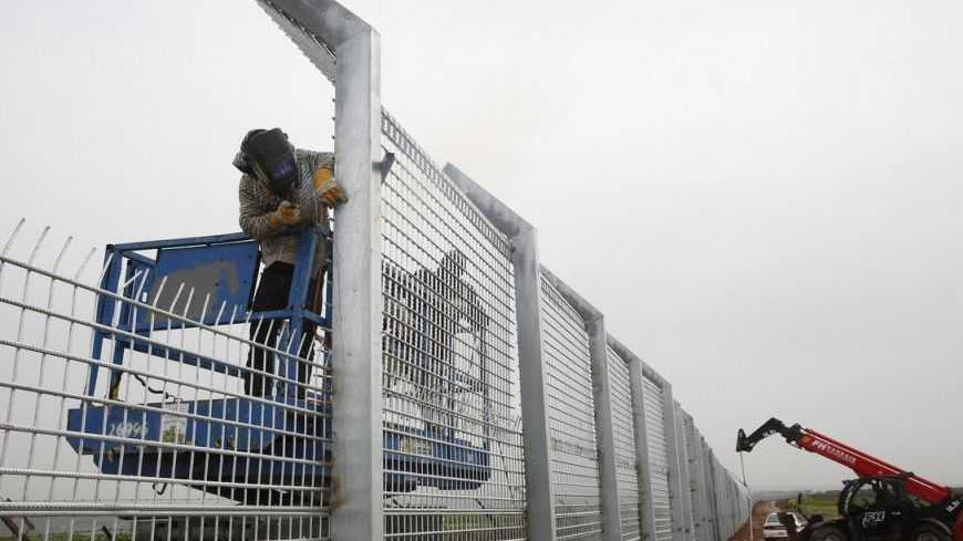 Labourers reinforce the fence near Israel's border with Syria in the Golan Heights February 14, 2013. Israel captured the Golan Heights from Syria in the 1967 Middle East war and annexed the territory in 1981, a move not recognised internationally. REUTERS/Baz Ratner (POLITICS) - RTR3DSEM