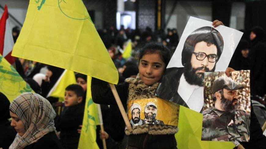 A child waves a Hezbollah flag as she holds pictures of martyrs as Hezbollah leader Sayyed Hassan Nasrallah addresses his supporters during a rally to commemorate Martyrs' Day in Beirut, February 16, 2013.  REUTERS/Sharif Karim (LEBANON - Tags: POLITICS) - RTR3DVC2