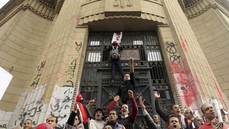 Protesters opposing Egyptian President Mohamed Mursi shout in front of the courthouse and Office of the Attorney General, which has been graffitied with anti-government slogans, during a protest against Mursi and members of the Muslim Brotherhood, near Tahrir Square in Cairo February 22, 2013. President Mohamed Mursi on Thursday called parliamentary elections that will begin on April 27 and finish in late June, a four-stage vote that the Islamist leader hopes will conclude Egypt's turbulent transition to de