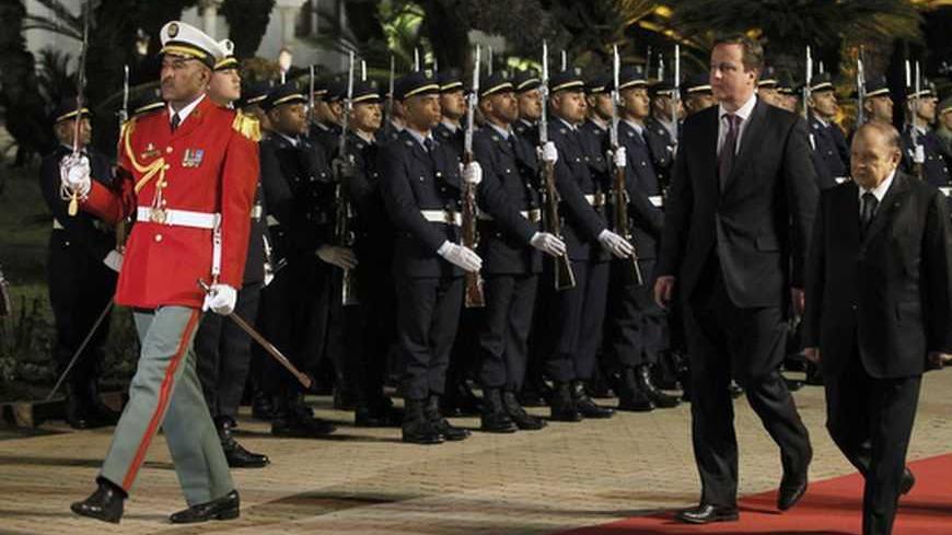 Algerian President Abdelaziz Bouteflika (R) and British Prime Minister David Cameron (2nd R) review the honour guard during a welcoming ceremony at the Presidential Palace in Algiers January 30, 2013.  REUTERS/Louafi Larbi (ALGERIA - Tags: POLITICS) - RTR3D62J