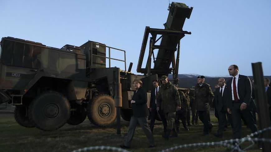 Germany's Chancellor Angela Merkel (L) walks past the Patriot system as she meets with troops from a German NATO  Patriot missile battery at a Turkish military base in Kahramanmaras February 24, 2013.  China and Russia are increasingly realizing that Syrian President Bashar al-Assad's time is up,  Merkel said on Sunday, as she visited German troops stationed with NATO Patriot missiles close to the Turkish-Syrian frontier. REUTERS/Murad Sezer (TURKEY  - Tags: POLITICS MILITARY) - RTR3E7WR