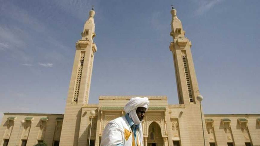 A man walks in front of the Saudi Mosque in central Nouakchott, February 2, 2008. Growing Al Qaeda presence in the Islamic Republic of Mauritania raises diplomatic and political concerns about security in Mauritania following three Al Qaeda attacks since December 2007. To match feature MAURITANIA-SECURITY/     REUTERS/Normand Blouin (MAURITANIA) - RTR1WZDE