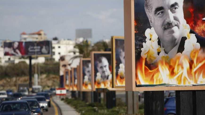 Cars drive past billboards of Lebanon's assassinated former prime minister Rafik al-Hariri at Sidon, southern Lebanon, February 13, 2011. The billboards were for the upcoming sixth anniversary of his assassination taking place on the 14th of February. REUTERS/Ali Hashisho (LEBANON - Tags: ANNIVERSARY POLITICS) - RTR2IJ5T