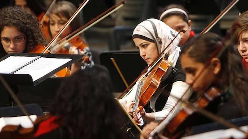 Members of the Jerusalem Orchestra play their instruments during a concert in the West Bank city of Ramallah January 22, 2012. Founded by Edward Said National Conservatory of  Music (ESNCM) in 2005, the Jerusalem Orchestra is the ESNCM's junior orchestra. It provides its Palestinian students with the experience of playing in an orchestra early in their musical education. REUTERS/Mohamad Torokman (WEST BANK - Tags: SOCIETY ENTERTAINMENT) - RTR2WOKI