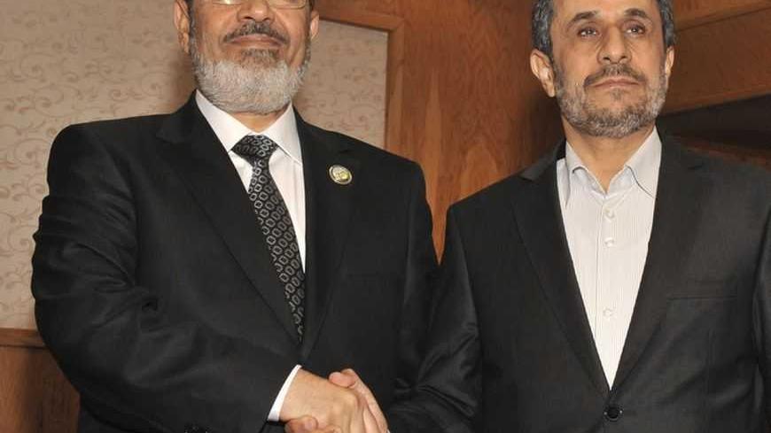 Egypt's President Mohamed Mursi (L) shakes hands with Iran's President Mahmoud Ahmadinejad during the 16th summit of the Non-Aligned Movement in Tehran August 30, 2012. Picture taken August 30, 2012. REUTERS/Egyptian Presidency/Handout (IRAN - Tags: POLITICS) FOR EDITORIAL USE ONLY. NOT FOR SALE FOR MARKETING OR ADVERTISING CAMPAIGNS. THIS IMAGE HAS BEEN SUPPLIED BY A THIRD PARTY. IT IS DISTRIBUTED, EXACTLY AS RECEIVED BY REUTERS, AS A SERVICE TO CLIENTS