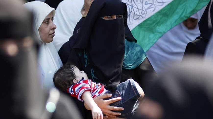 A Palestinian woman holds her son during a protest in Gaza City calling for the release of Palestinian prisoners from Israeli jails September 24, 2012. REUTERS/Mohammed Salem (GAZA - Tags: POLITICS CIVIL UNREST) - RTR38CL0