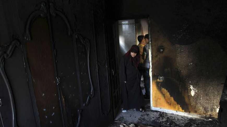 A Palestinian woman looks at a burnt room of three-year-old boy Fathi al-Bogdadi in Bureij refugee camp in the central Gaza Strip September 26, 2012. Al-Bogdadi died and his infant sister suffered critical burns when a candle lit amid a power outage burnt their house down. REUTERS/Ibraheem Abu Mustafa (GAZA - Tags: POLITICS DISASTER) - RTR38FOR