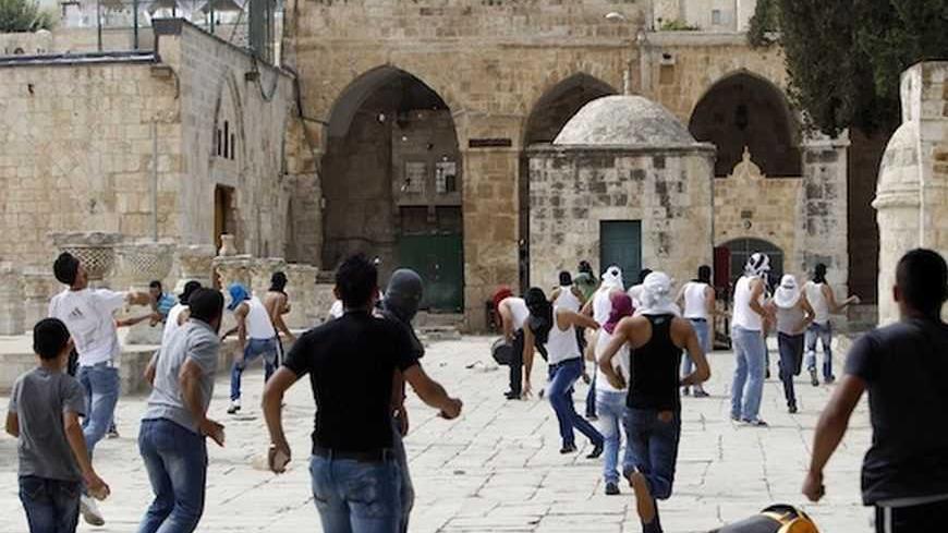 Palestinian youths throw stones during clashes with Israeli security forces near al-Aqsa mosque on the compound known to Muslims as Noble Sanctuary and to Jews as Temple Mount in Jerusalem's Old City October 5, 2012. Israeli police hurled stun grenades to disperse dozens of the protesters who threw stones outside the mosque, Islam's third holiest site, after Friday prayers. Tensions flared this week at the site after police arrested Israeli ultranationalists who tried to hold prayers at the compound revered