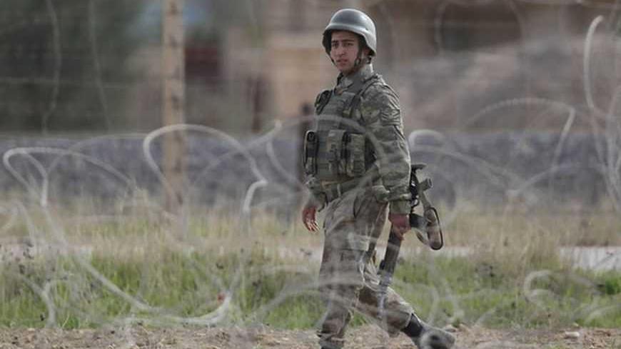 A Turkish soldier walks on the Turkish-Syrian border in Ceylanpinar, southern Sanliurfa province November 13, 2012. A Syrian warplane struck homes in the town of Ras al-Ain on Tuesday within sight of the Turkish border, pursuing an aerial bombardment to force out rebels, a Reuters witness and refugees said.The second day of jet strikes sent Syrians scurrying through the flimsy barbed-wire fence that divides Ras al-Ain from the Turkish settlement of Ceylanpinar, thick plumes of smoke rising above the town. R