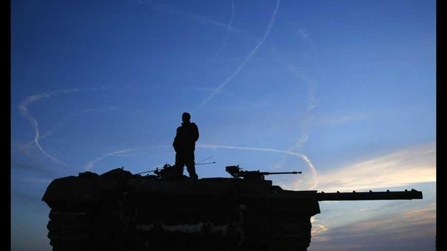 An Israeli soldier atop a tank looks at air force fighter jets circling overhead an Israeli Defence Forces (IDF) staging area in the northern Gaza border November 21, 2012. Israeli air strikes shook the Gaza Strip and Palestinian rockets struck across the border as U.S. Secretary of State Hillary Clinton held talks in Jerusalem in the early hours of Wednesday, seeking a truce that can hold back Israel's ground troops.  REUTERS/Yannis Behrakis (ISRAEL - Tags: CONFLICT MILITARY POLITICS TRANSPORT TPX IMAGES O