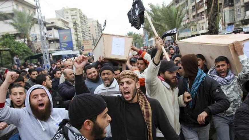 Lebanese Sunni Islamists shout slogans as they carry coffins of Lebanese Islamist militants after their bodies arrived from Syria, in Tripoli, northern Lebanon December 22, 2012. Funerals will be held in Lebanon for three Lebanese Islamist militants killed while fighting with rebels in Syria. REUTERS/Omar Ibrahim (LEBANON - Tags: POLITICS CIVIL UNREST TPX IMAGES OF THE DAY) - RTR3BU8I