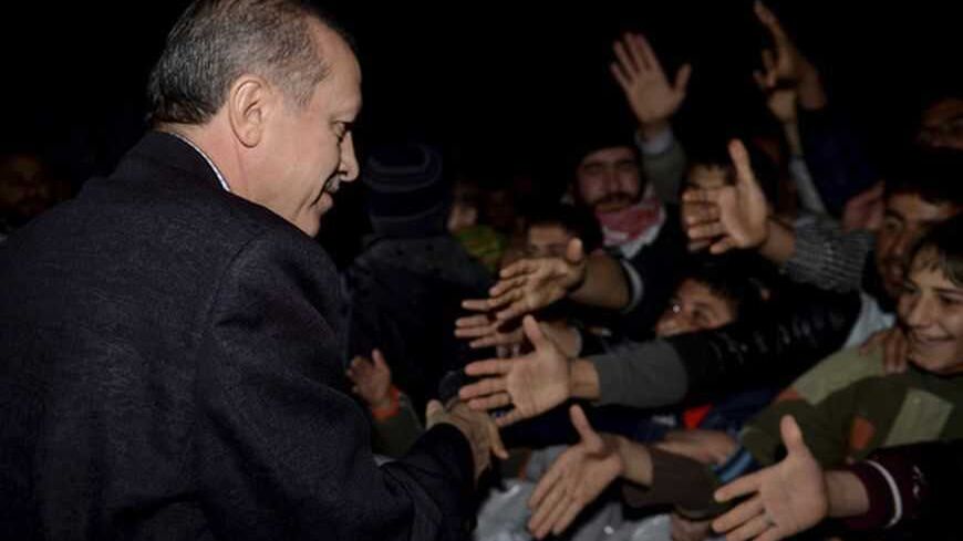 Turkish Prime Minister Tayyip Erdogan shakes hands with Syrian refugees as he visits a refugee camp near Akcakale border crossing on the Turkish-Syrian border, southern Sanliurfa province, December 30, 2012. REUTERS/Kayhan Ozer/Prime Minister's Press Office/Handout (TURKEY - Tags: POLITICS CONFLICT) FOR EDITORIAL USE ONLY. NOT FOR SALE FOR MARKETING OR ADVERTISING CAMPAIGNS. THIS IMAGE HAS BEEN SUPPLIED BY A THIRD PARTY. IT IS DISTRIBUTED, EXACTLY AS RECEIVED BY REUTERS, AS A SERVICE TO CLIENTS - RTR3BZG7