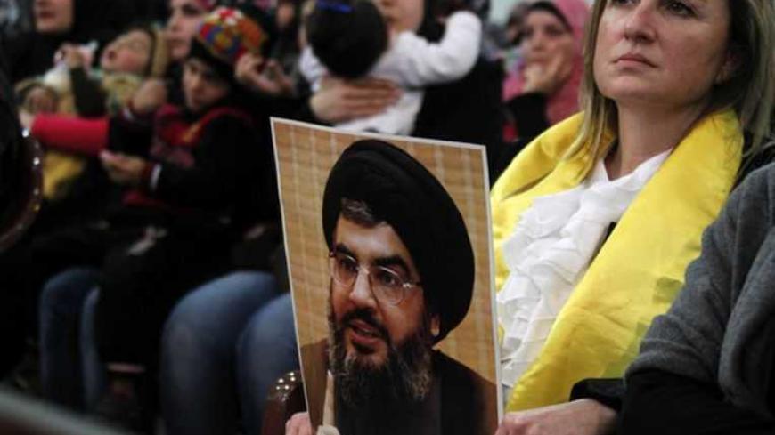 A woman holds a picture of Lebanon's Hezbollah leader Sayyed Hassan Nasrallah during a rally to commemorate the birth of Prophet Mohammad in Beirut's suburbs, January 25, 2013.  REUTERS/Sharif Karim (LEBANON - Tags: POLITICS) - RTR3CY5K