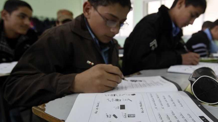 A Palestinian student writes during a Hebrew language class in a Gaza school in Gaza City January 28, 2013. REUTERS/Ahmed Zakot (GAZA - Tags: EDUCATION) - RTR3D31Q
