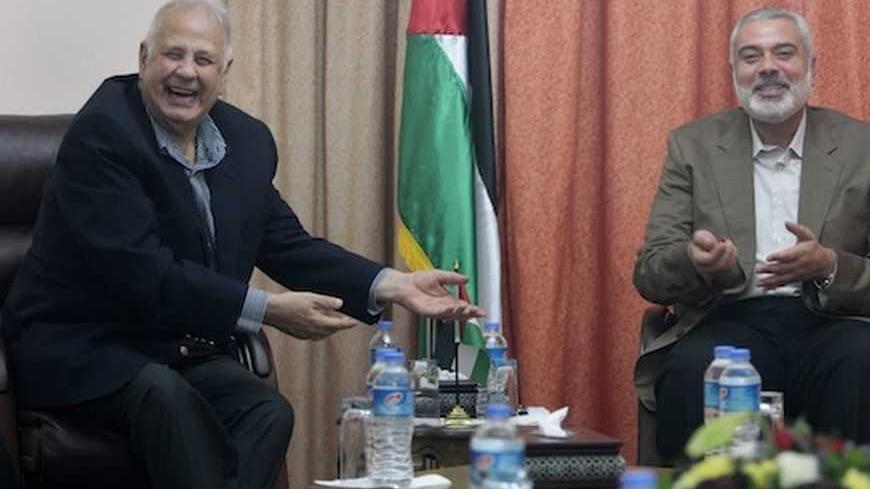 Hamas prime minister Ismail Haniyeh (R) gestures during a meeting with Hanna Nasir (L), chairman of the Palestinian Central Election Commission (CEC), in Gaza City January 30, 2013.  REUTERS/Ahmed Zakot (GAZA - Tags: POLITICS) - RTR3D57Q