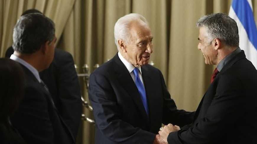 Israel's President Shimon Peres (C) shakes hands with Yair Lapid, leader of the Yesh Atid (There's a Future) party, in Jerusalem January 30, 2013, after receiving the official results of the general elections held on January 22. Peres on Wednesday began consultations with political parties over the formation of a new coalition and appears certain to pick incumbent Prime Minister Benjamin Netanyahu to assemble it. Lapid's new centrist party stormed to second place in last week's election by winning 19 seats.