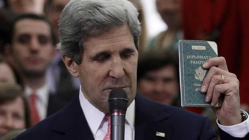 John Kerry, the new U.S. Secretary of State, holds the diplomatic passport he was issued at eleven years old, while greeting employees of the State Department in Washington February 4, 2013. Kerry's father, Richard, was a U.S. Foreign Service officer in Berlin after World War II.   REUTERS/Gary Cameron   (UNITED STATES - Tags: POLITICS TPX IMAGES OF THE DAY) - RTR3DCG4