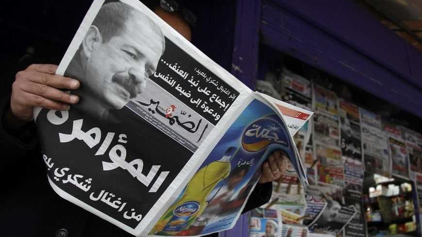A man reads a local newspaper, displaying a picture of assassinated prominent Tunisian opposition politician Chokri Belaid, at a kiosk in Tunis February 7, 2013. Tunisia's Islamists rejected on Thursday a plan by their party chief and prime minister to change the government after unrest erupted over the killing of an opposition leader, deepening the worst crisis since a 2011 revolution. Labour union leaders agreed to stage a general strike on Friday and the family of assassinated secular politician Chokri B