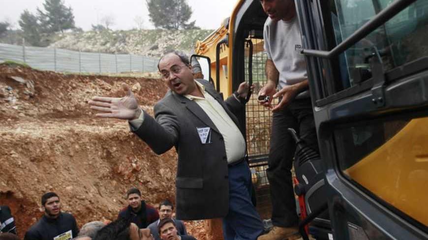 Israeli Arab Parliament member Ahmed Tibi (C) gestures as he stands on a bulldozer during a demonstration against Israel's construction of a road in the Arab neighbourhood of Beit Safafa in Jerusalem February 10, 2013. Some 50 Palestinians protested against the construction of the road, which they claim is an expropriation of their land. REUTERS/Ammar Awad (JERUSALEM - Tags: POLITICS CIVIL UNREST BUSINESS CONSTRUCTION) - RTR3DL5H
