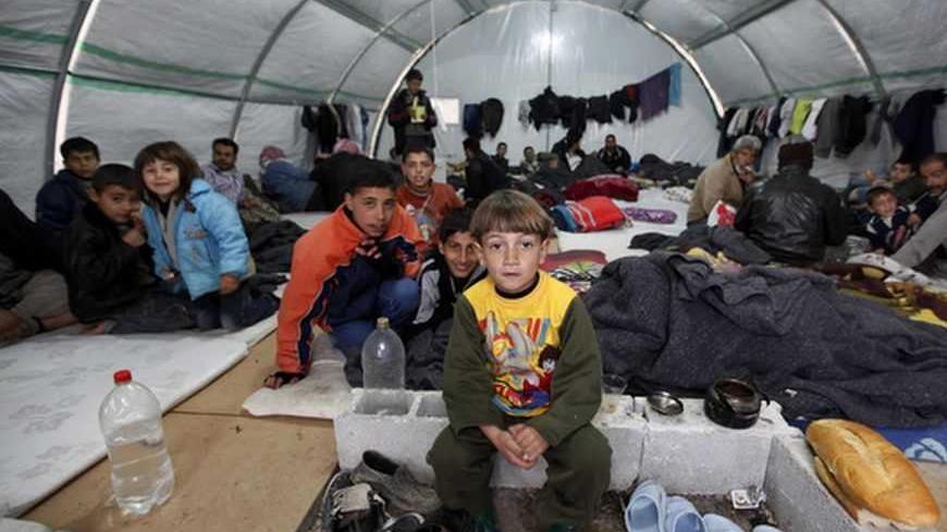 Syrian refugees sit in a tent at a refugee camp in the town of Nizip in Gaziantep province, southeast Turkey, February 11, 2013. REUTERS/Umit Bektas (TURKEY - Tags: POLITICS SOCIETY IMMIGRATION TPX IMAGES OF THE DAY) - RTR3DNGY