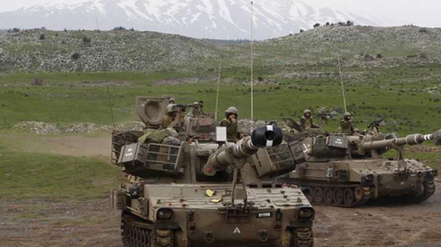 Mount Hermon is seen in the background as Israeli soldiers travel on mobile artillery units after an exercise in the Golan Heights, near Israel's border with Syria February 14, 2013. Israel captured the Golan Heights from Syria in the 1967 Middle East war and annexed the territory in 1981, a move not recognised internationally. REUTERS/Baz Ratner (POLITICS MILITARY) - RTR3DSD4