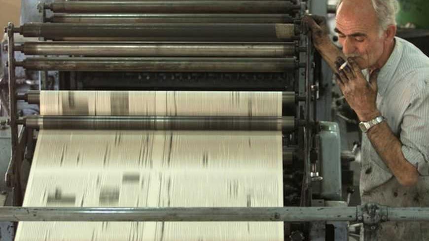 A pressman keeps watch on the print run of the first Baghdad edition of the Patriotic Union of Kurdistan's newspaper April 22, 2003. The printing press in the Bab al-Muadham district used to print the official al-Iraq newspaper, and also issued the last editions of Iraq's three other main official newspapers because other presses were out of action. But it has been taken over by a Kurdish group, the Patriotic Union of Kurdistan (PUK), and will now produce a newspaper called Al-Ittihad. - RTXLWW2